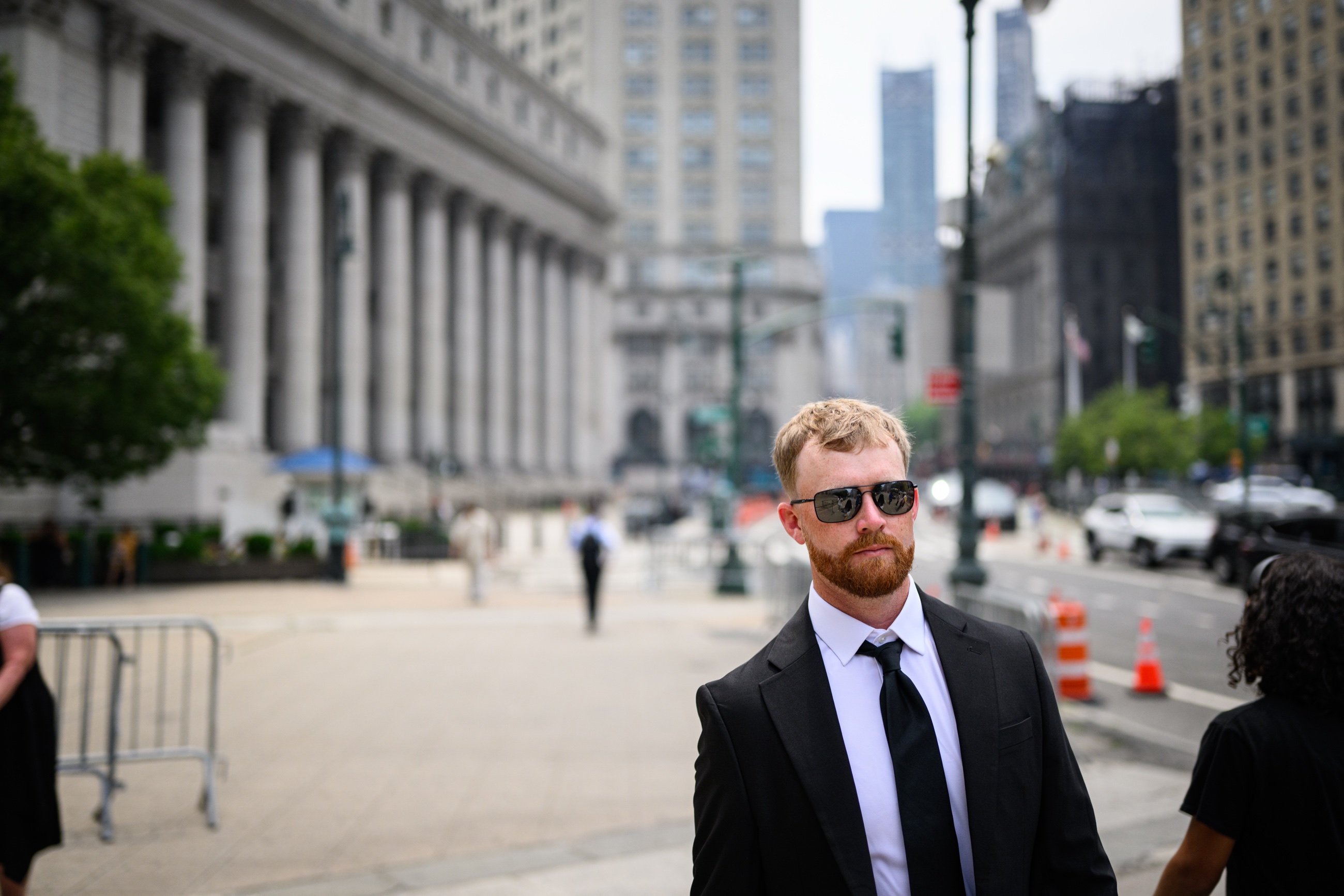 A man in a dark suit outside a Manhattan courthouse
