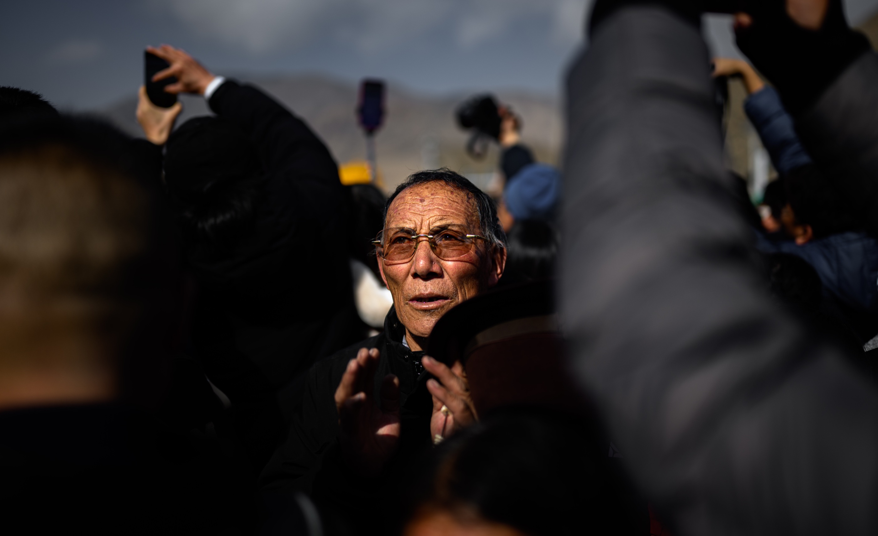 An older man within the ceremony crowd