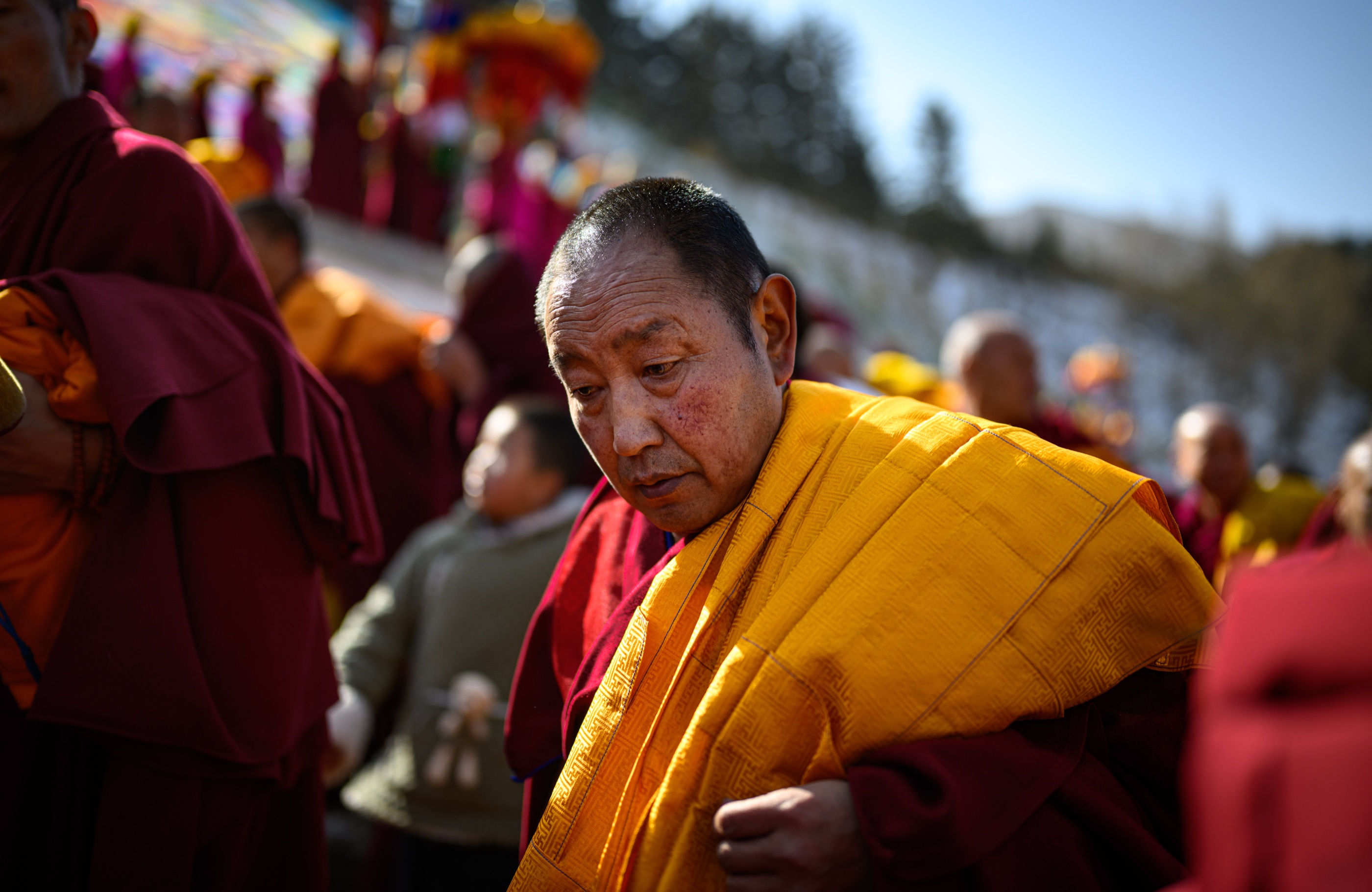 A monk wearing a yellow ceremonial robe